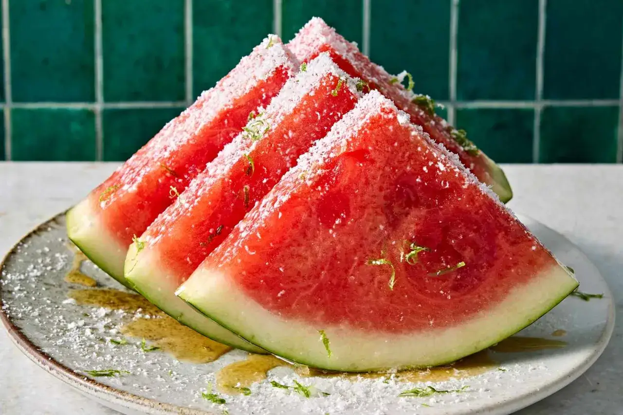 Saftige Wassermelonenst&uuml;cke, bestreut mit Kokosraspeln und Limettenzesten, perfekt zum Wassermelone abends essen.