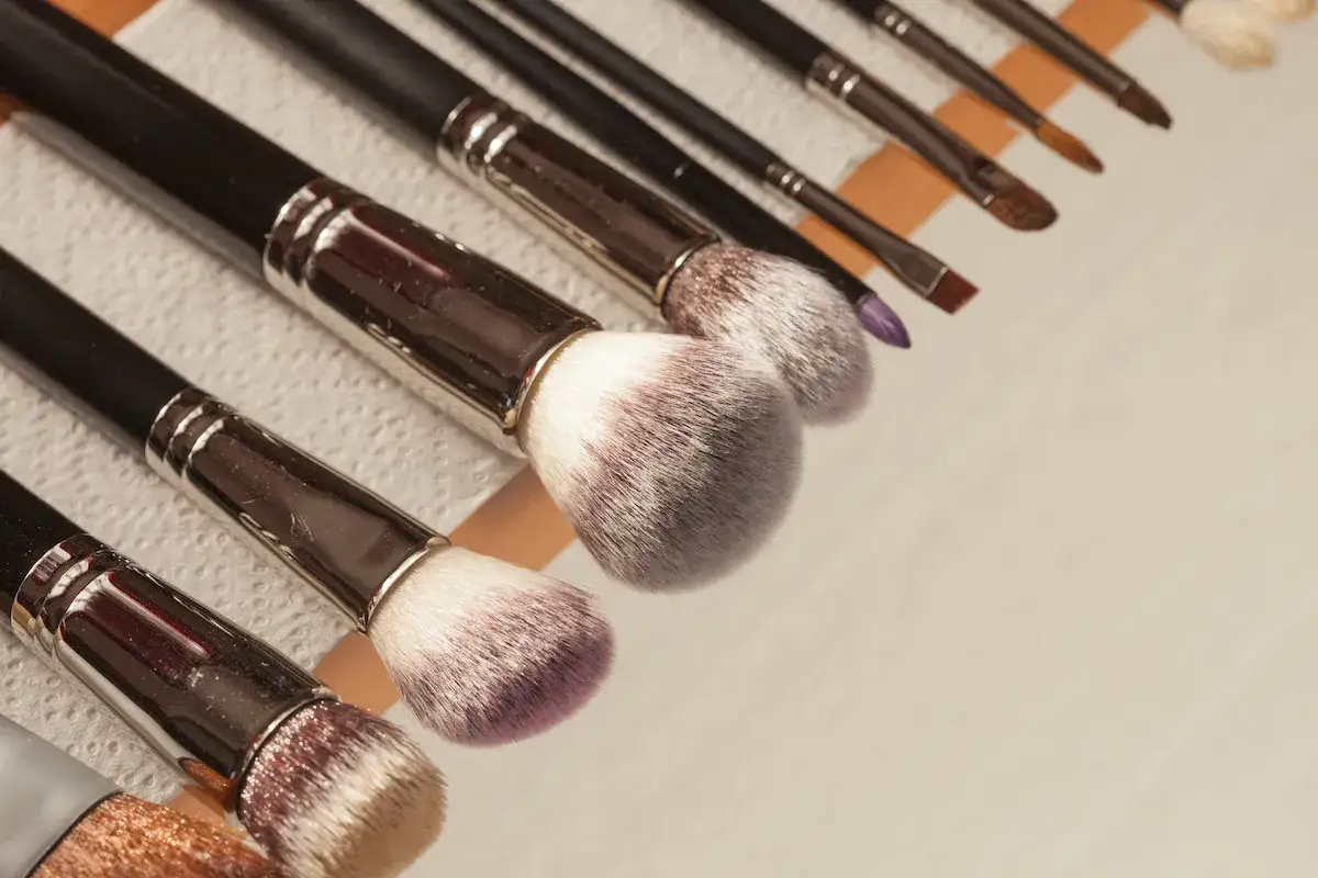 Reihe von Make-up-Pinseln, die auf einem Papiertuch liegen, bereit zum pinsel reinigen.