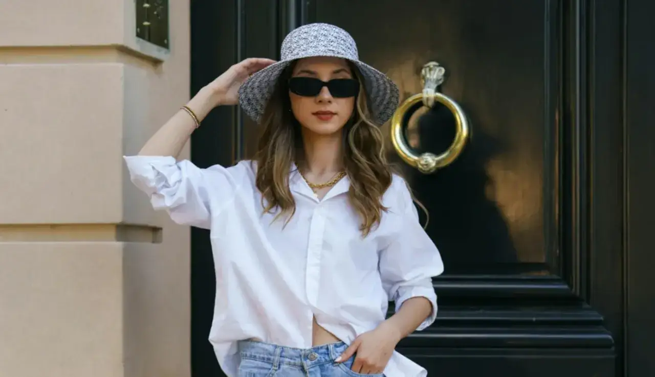 Stylisches Outfit: wei&szlig;e Bluse, Jeans und Hut &ndash; perfekt, um bei 20 Grad stilvoll anzuziehen.