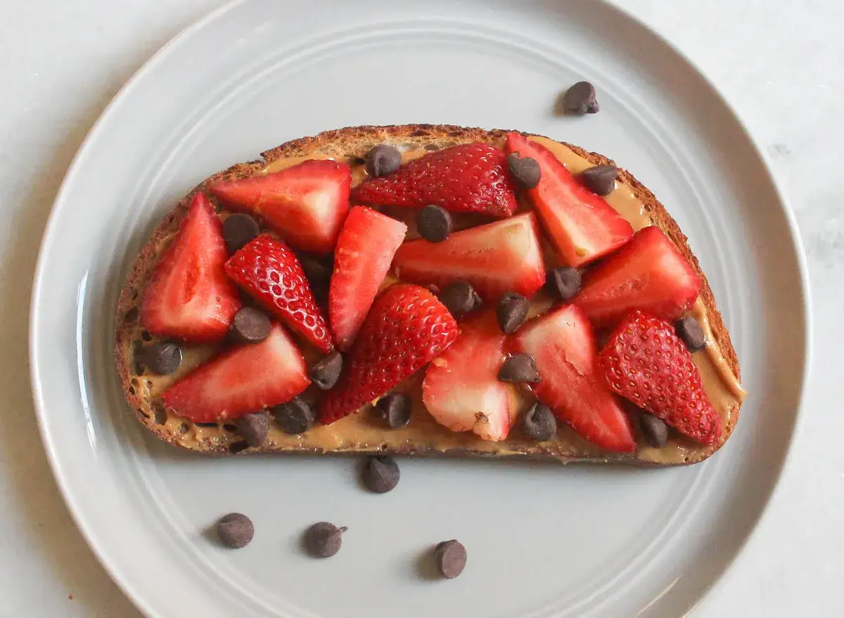 Vollkornbrot mit cremiger Erdnussbutter, frischen Erdbeeren und Schokodrops. Ein leckerer und gesunder Snack!