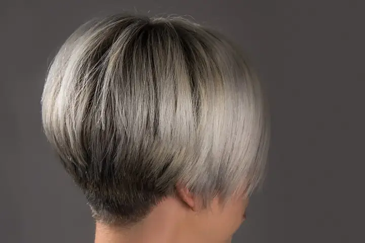 Ein moderner, kurzer Bob mit sehr feinem Haar, das von dunkel zu hellblond verläuft.